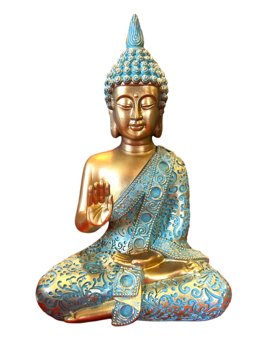 Decorative statue of a seated Buddha with blue and gold details on a red surface.